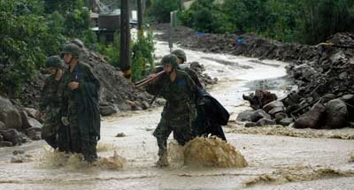 图为救援官兵冒雨参与抗洪抢险。