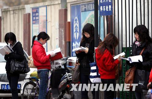 11月29日，考生在上海徐汇区零陵中学考点外抓紧时间看书复习。新华社记者 刘颖 摄