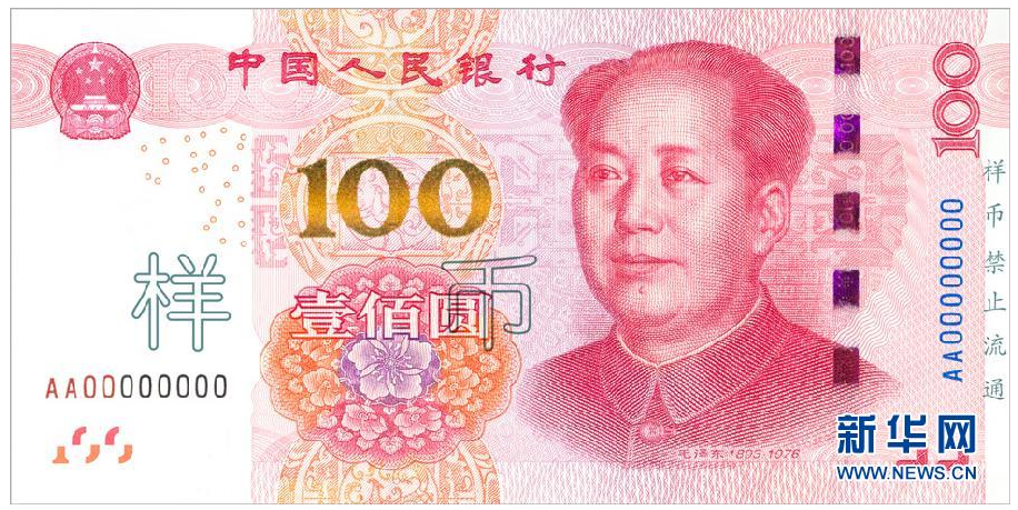 中国印钞造币总公司技术总监邵国伟在他的办公室展示新版百元钞票(上)与旧版的不同(10月30日摄)。
