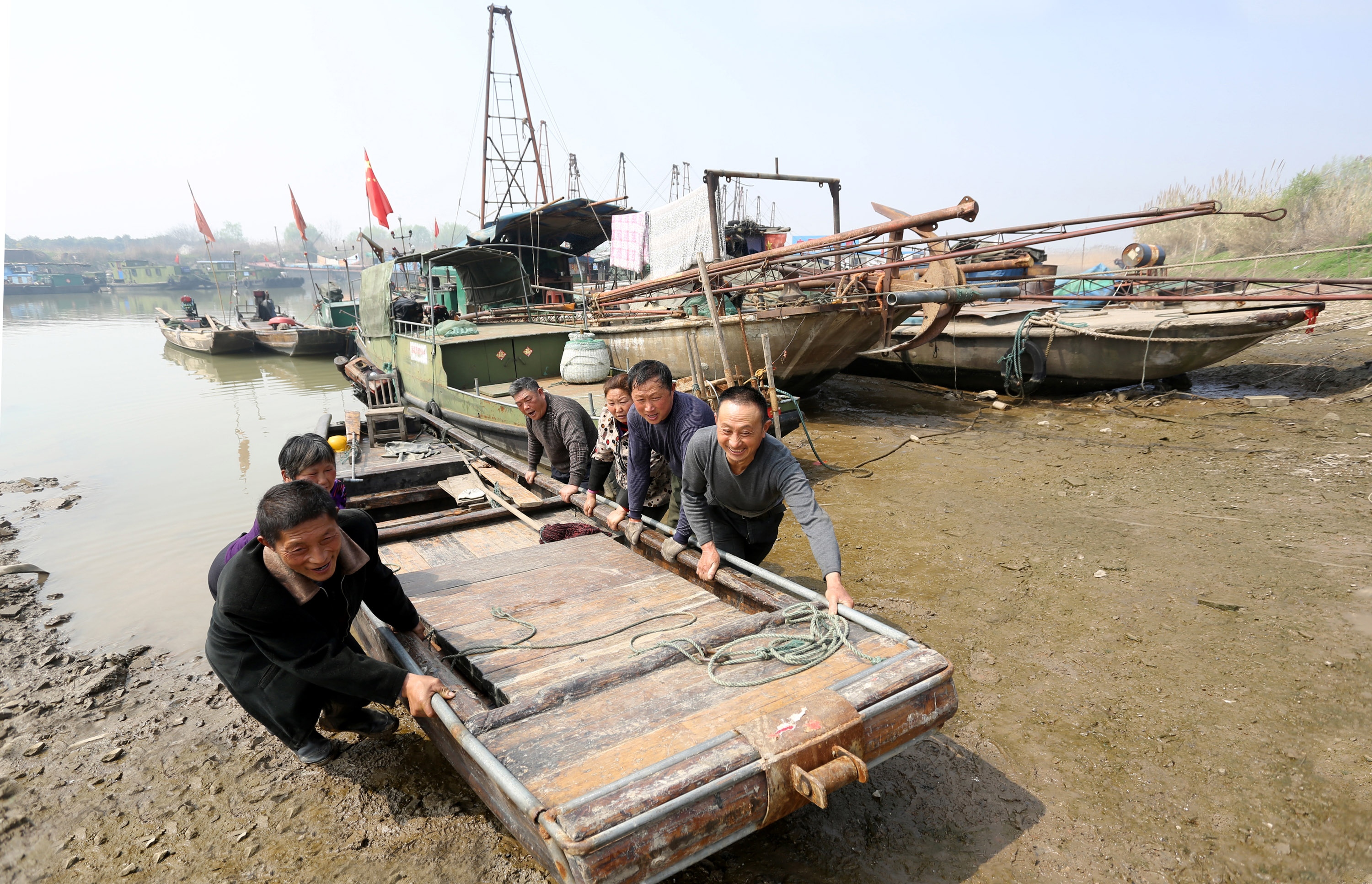 休渔季来临，渔民将渔船拖上岸